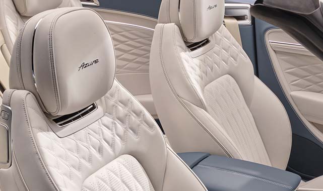 Luxurious front seats featuring diamond-quilted white leather upholstery with embroidered Azure branding on the headrests.