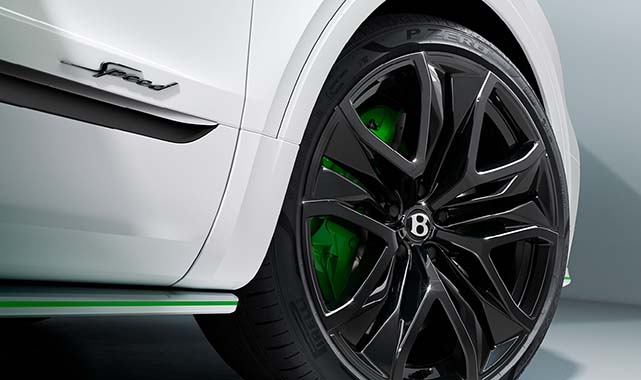 Side view of Bentley Bentayga Speed’s black alloy wheel with green brake calipers and Speed badging.