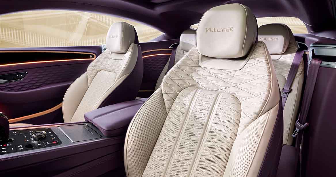 Bentley Continental GT featuring quilted cream leather seats, purple accents, ambient lighting, and detailed stitching for a refined driving experience.