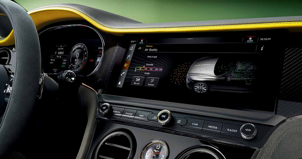 A sporty Bentley dashboard with black and yellow contrast stitching, carbon fiber accents, and a digital air quality interface on the central display.