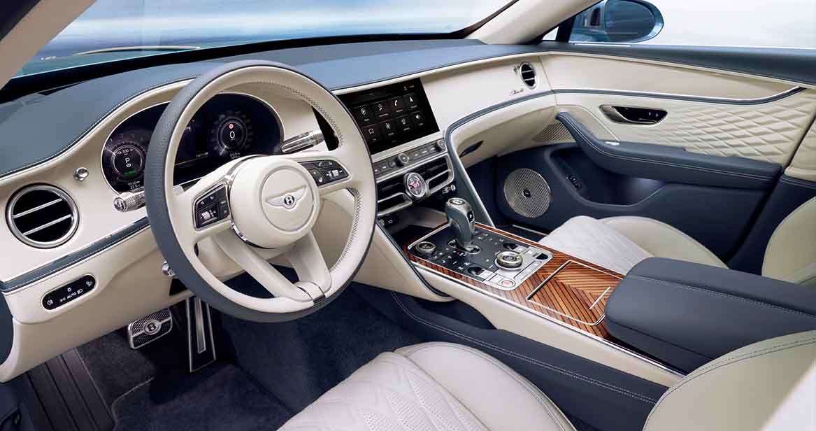 Interior cabin of the Bentley Flying Spur showcasing a two-tone ivory and navy blue leather interior with diamond-quilted door panels.