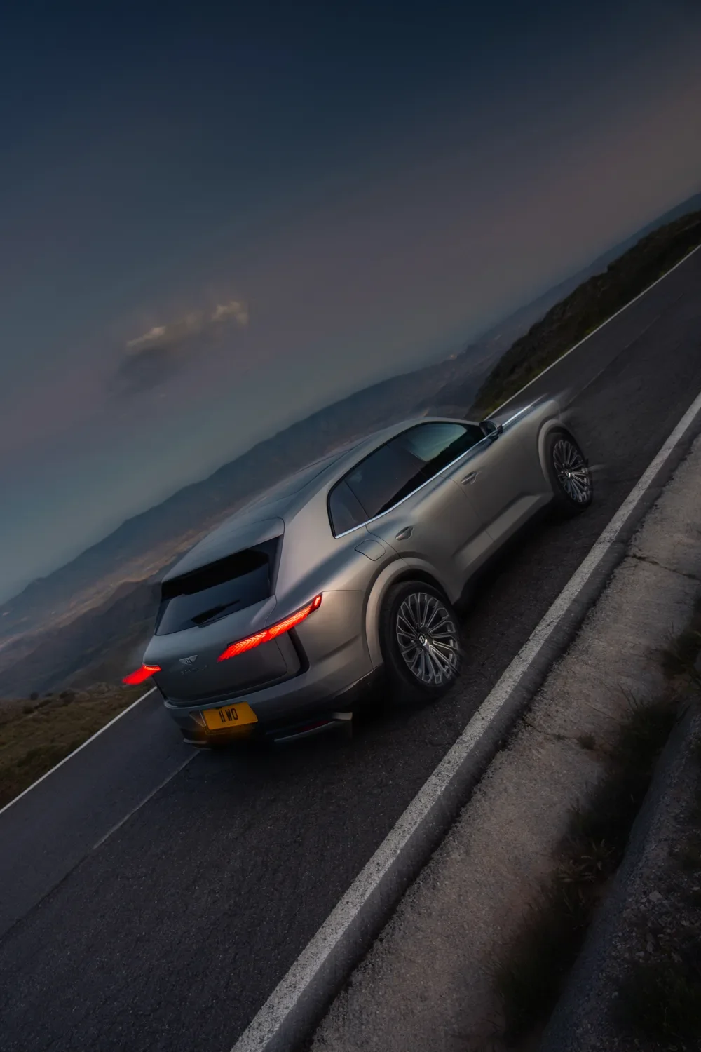 Overhead view of a Bentley Torcal cornering on a coastal mountain road